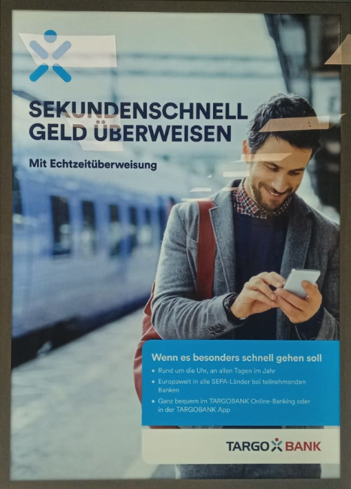 Werbeplakat von Targo-Bank mit dem Titel "Sekundenschnell Geld überweisen mit Echtzeitüberweisung"