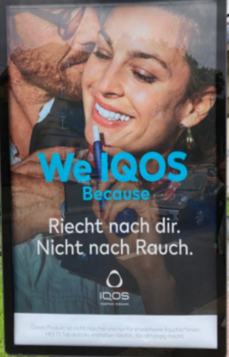Werbeplakant der Firma "IQOOS" und dem Titel "We IQOS Because Riecht nach dir. Nicht nach Rauch."