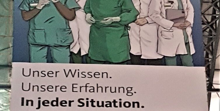 Foto eines Werbeplakates mit fünf in der Medizin tätigen Personen und dem Titel "Unser Wissen. Unsere Erfahrung. In jeder Situation."