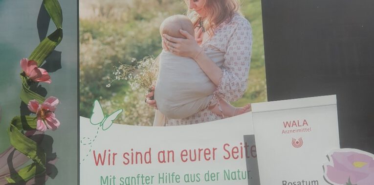 Bild eines Werbeflyers für Wala Arzneimittel, das eine Frau mit einem Baby zeigt und dem Titel "Wir sind an eurer Seite. Mit sanfter Hilfe aus der Natur"