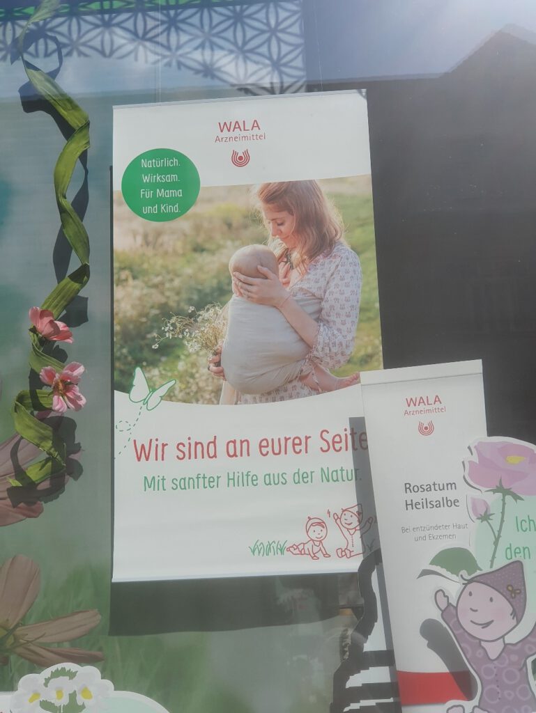 Bild eines Werbeflyers für Wala Arzneimittel, das eine Frau mit einem Baby zeigt und dem Titel "Wir sind an eurer Seite. Mit sanfter Hilfe aus der Natur"