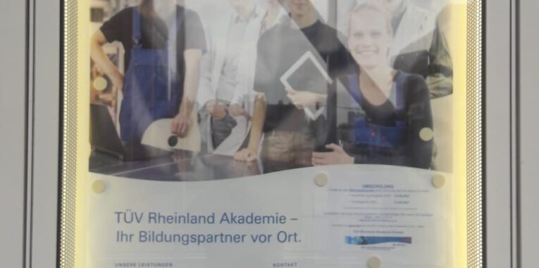 Foto eines Plakates der TÜV Rheinland Akademie mit sechs verschiedenen Personen