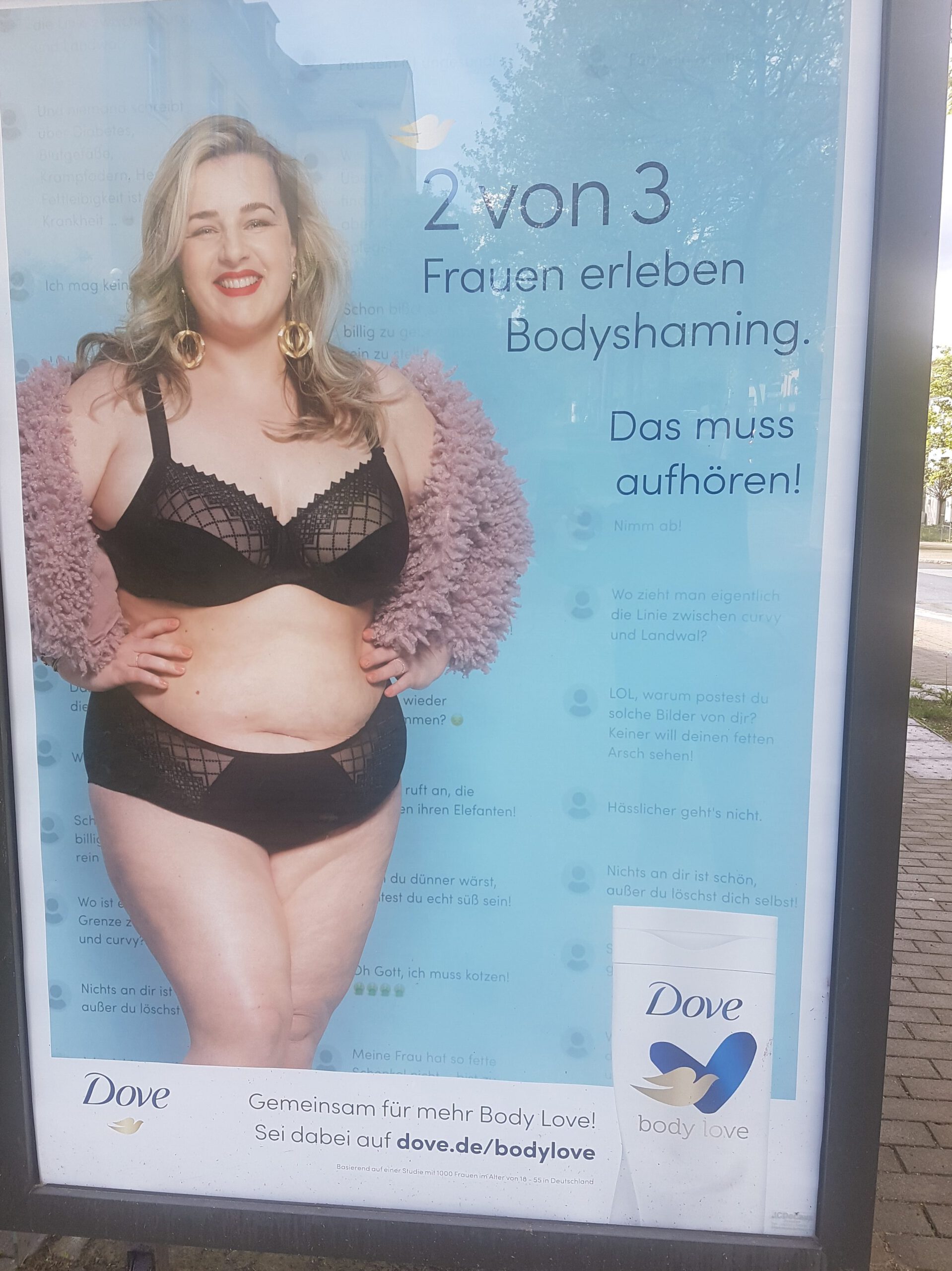 Werbeplakat von Dove mit dem Titel "2 von 3 Frauen erleben Bodyshaming" und eine hell häutigen, blonden Frau.