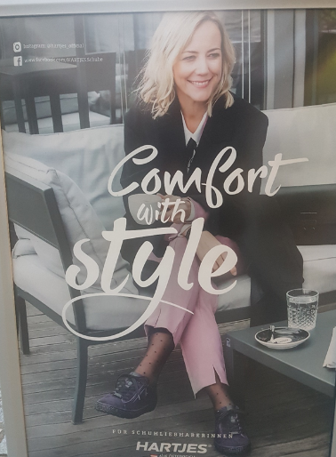 Werbeplakat mit dem Title "Comfort in Style" mit einer blonden Frau auf einer Bank.